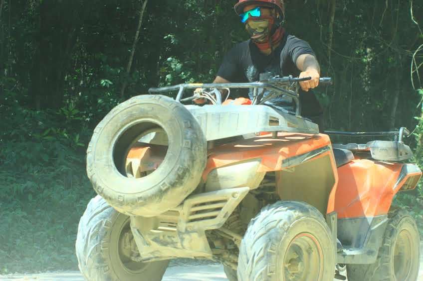 ATV adventure through challenging forest terrain with scenic natural backdrop